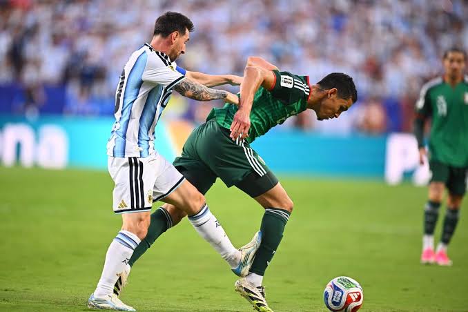 Lionel Messi makes contact from behind with Algeria captain Aïssa Mandi